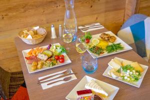 伊索拉2000SOWELL HOTELS Le Pas du Loup的餐桌,三盘食物和酒杯