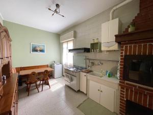 佩斯基耶拉德加达Appartamento 2, Villa Magnolia, 64mq, Lago di Garda的厨房配有桌子和炉灶。 顶部烤箱