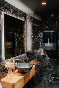 蒙达卡Hotel Luruna Palacio Larrinaga的黑色浴室设有水槽和镜子