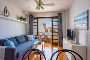 法纳贝海滩Garden City Private Apartment Costa Adeje的客厅配有蓝色的沙发和桌子
