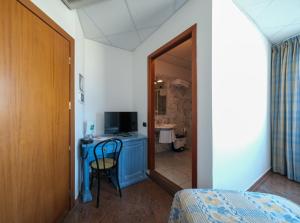 马里纳·迪·比萨L'incanto Di Boccadarno的一间卧室配有一张床和一张书桌及电视