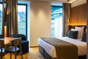 安锡Le Pélican的酒店客房设有床、桌子和窗户。