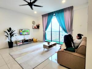 怡保Ipoh Meru - Spacious - 20mins Ipoh Town - 20mins Tambun - Pool View - Near Bus Station - Free 3 Parking by Happy Homestay的坐在客厅沙发上的女人