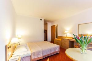 科沃布热格Hotel Solny的酒店客房配有一张床铺和一张桌子。