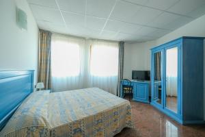 马里纳·迪·比萨L'incanto Di Boccadarno的一间卧室配有蓝色的床和电视