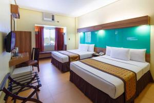 达沃市温德姆达沃麦克罗酒店的酒店客房配有两张床和一张书桌
