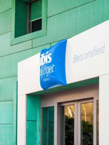 比肯斯菲尔德ibis budget Beaconsfield的建筑物一侧的蓝色和白色标志