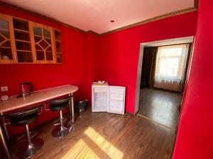 里加Apartamenti的厨房设有红色的墙壁、柜台和凳子
