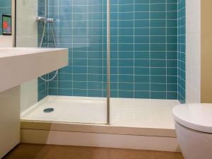 图尔风格旅游中心宜必思酒店的浴室设有蓝色瓷砖淋浴。