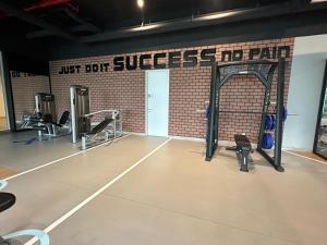 吉隆坡Sentral Suites KualaLumpur的健身房设有数台跑步机和砖墙
