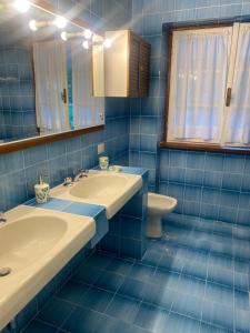 RoncobelloVilla Bordogna in Val Brembana nel cuore delle prealpi的蓝色瓷砖浴室设有2个盥洗盆和1个卫生间