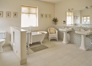 赫特福德Bridge House at Woodhall Estate的一间带两个盥洗盆、浴缸和卫生间的浴室