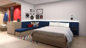什切青Hampton By Hilton Szczecin East的一间卧室配有一张大床和一张蓝色的沙发