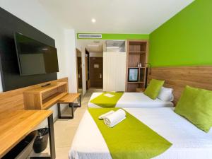 大加那利岛拉斯帕尔马斯Hotel MG Poniente的绿墙客房的两张床