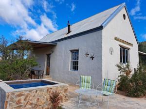 莱迪史密斯Wolverfontein Karoo Cottages的一座带游泳池和两把椅子的房子