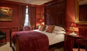 伦敦巴蒂兰利酒店的一间卧室设有一张带红色墙壁的大床