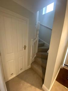 切尔滕纳姆Cotswold Cottage的一条带白色门的楼梯和带有窗户的楼梯