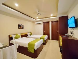 AngulHotel Jasmin Palace的酒店客房设有两张床和一台平面电视。