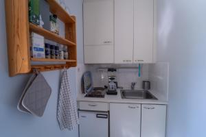 MatildedalMathildedal private holiday apartment nr. 7的小厨房配有白色橱柜和水槽
