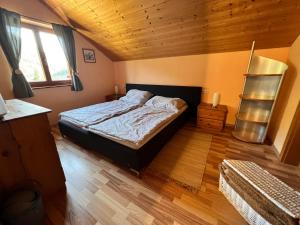 多恩比恩Haus Susi的一间卧室设有一张床和木制天花板