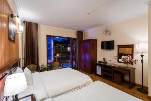 萨帕May Ho Hotel Sapa的酒店客房配有两张床和一张书桌