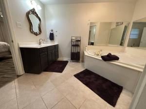 基尔戈Magnolia Grace Place的带浴缸、水槽和镜子的浴室