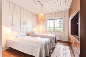 米凯利World's End - 2 Luxury Beachfront Villas (425m2)的一间卧室配有两张床和电视。