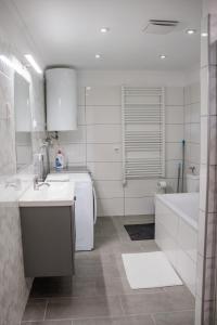 维斯普雷姆Monbuhim Premier的白色的浴室设有浴缸、水槽和浴缸。