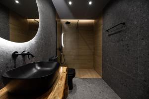 扎金索斯镇Sogni D' Oro的一间带黑色浴缸和淋浴的浴室