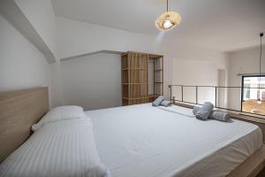 扎金索斯镇Sogni D' Oro的一间白色卧室,配有两张床和窗户