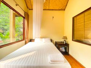宁平Tam Coc Rocky Bungalow的一间卧室设有一张大床和一个窗户。