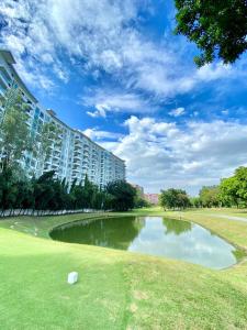 马尼拉1BR Condo at Montecito Newport City Residential Resort across NAIA and Marriott Hotel的一个大建筑前的池塘