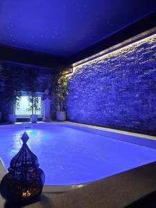 绍德方丹Le Clos des Thermes Suites de Luxe avec wellness privatif的一座晚上在房子里点亮的游泳池