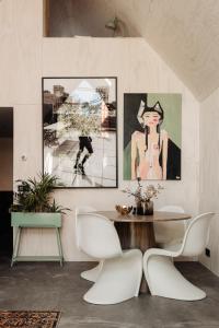 卑尔根Studio Verver的一间用餐室,配有一张桌子和两幅墙上的画作