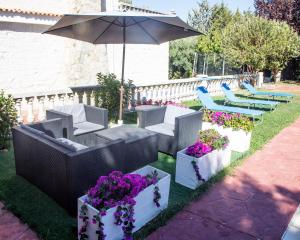 哈恩Villa Fuji Sierra de la Pandera Jaén的庭院设有椅子和鲜花,配有遮阳伞