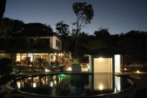 库穆鲁沙蒂巴Pousada Maré的夜间在房子前面的游泳池