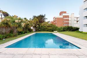 埃斯特角城Oceana Suites en Esturion, frente a playa Brava的庭院中间的游泳池