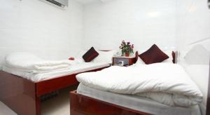 香港Relaince Inn的两张睡床彼此相邻,位于一个房间里