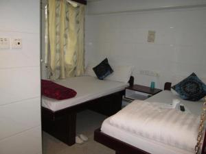 香港Relaince Inn的小房间设有两张床和窗户