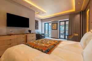 阿尔布费拉Vila Origens Boutique Hotel Albufeira – Adults Only的一间卧室设有一张大床和一台平面电视。