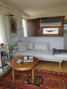EinigenNEB-THUN Einigen, Wohnung am See的客厅配有白色的沙发和桌子