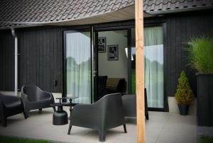 WapenveldLa Vita Veluwe的庭院配有椅子、桌子和玻璃门