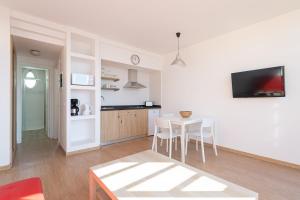 英格兰海滩Apartamentos Cordial Judoca Beach的厨房以及带桌椅的用餐室。