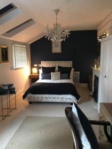 A luxury Boutique Barn set within 2 acre grounds的一间卧室配有一张大床和一个吊灯。