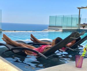 依拉佩特拉Zax sea view villas的两个女孩躺在游泳池里