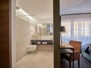 弗利斯富力色霍夫全景酒店的一间带水槽和卫生间的浴室以及一张书桌。