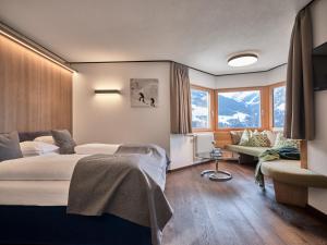 弗利斯富力色霍夫全景酒店的一间卧室配有一张床、一张沙发和窗户。