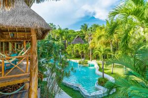 普拉亚卡门Mahekal Beach Front Resort & Spa的一个带游泳池和棕榈树的度假村