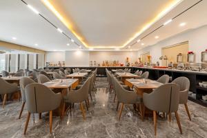 岘港Mercy Emerald Hotel的用餐室配有木桌和椅子