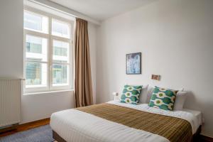 安特卫普Smartflats - Central Antwerp的一间卧室设有一张床和两个窗户。